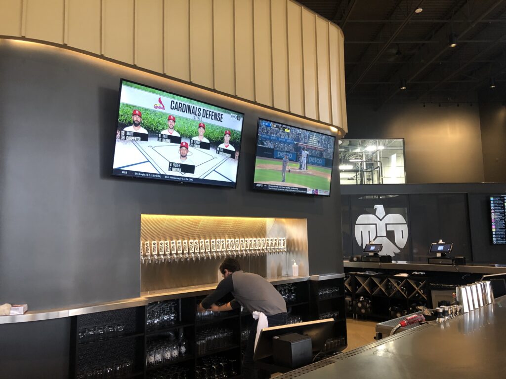 Commercial audio-visual installation by Brew City PC — bank of TV displays mounted behind and above a bar